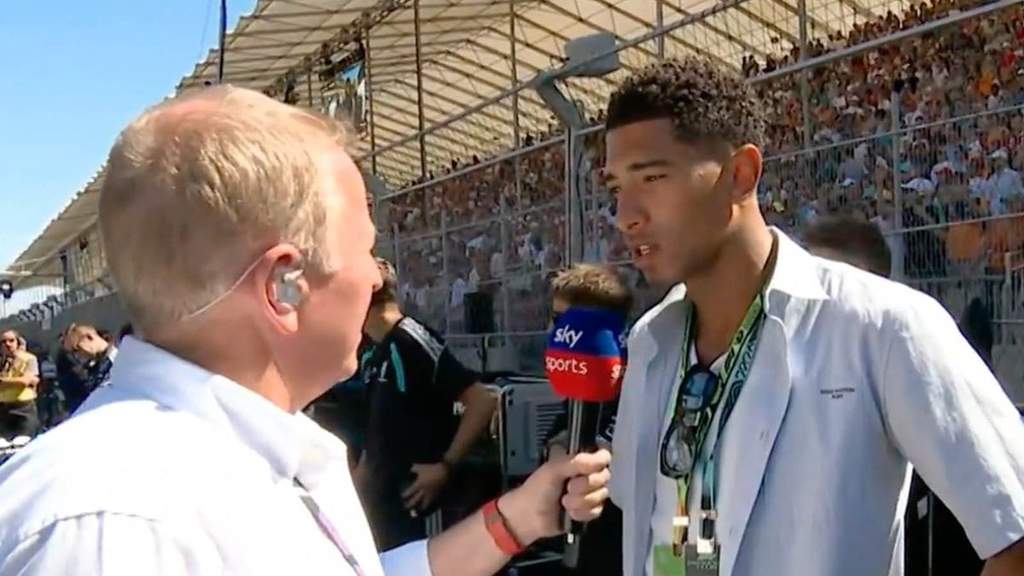 Jude Bellingham tersenyum saat diwawancarai Martin Brundle di grid F1