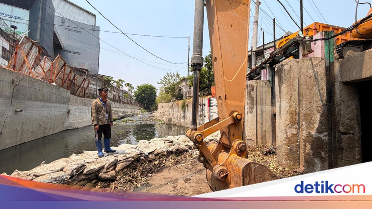Pekerja menggunakan alat berat mengeruk sedimentasi sungai untuk atasi banjir di Simo Surabaya