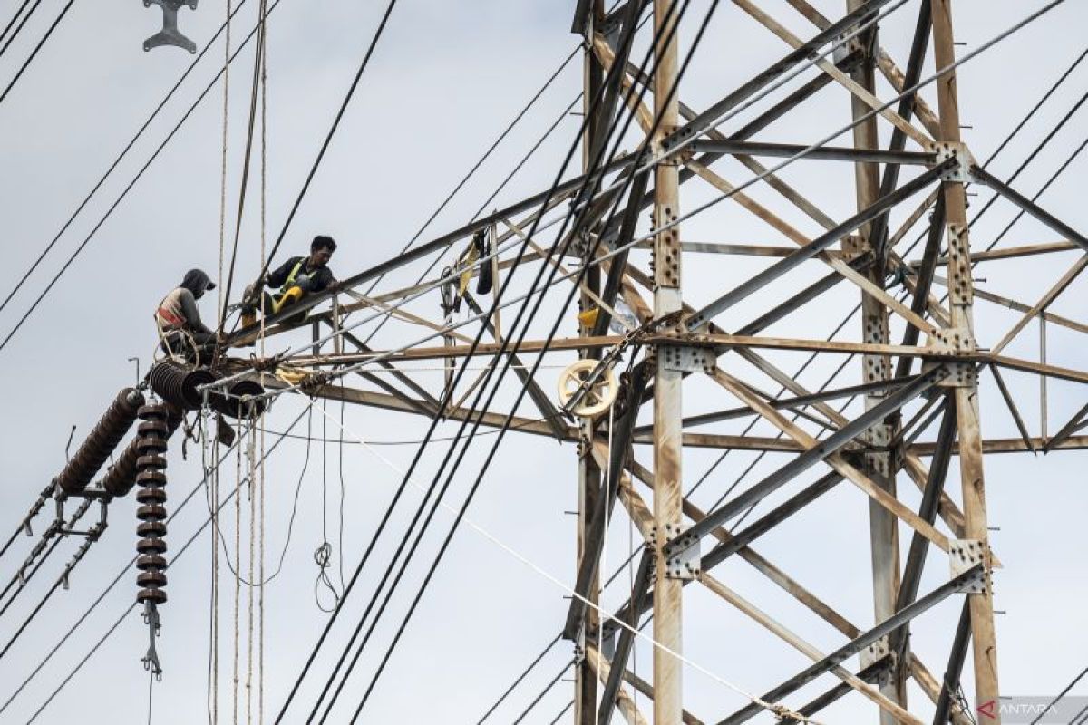 Pekerja sedang memeriksa infrastruktur jaringan listrik tegangan tinggi di gardu induk