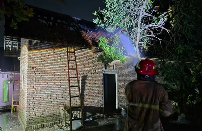Petugas pemadam kebakaran berjibaku memadamkan api di rumah warga Jombang