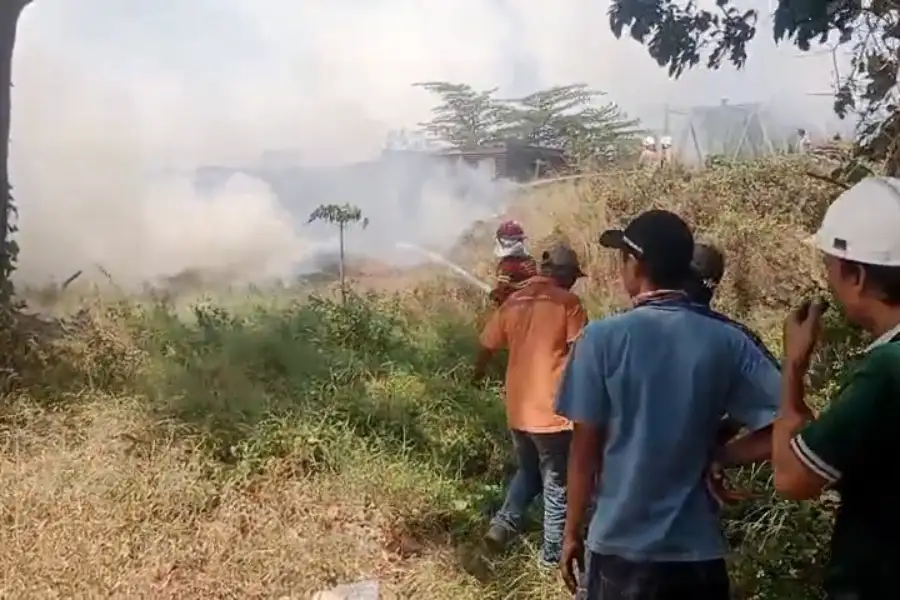 Petugas pemadam kebakaran memadamkan tumpukan ampas tebu yang terbakar di PG Gempolkrep Mojokerto