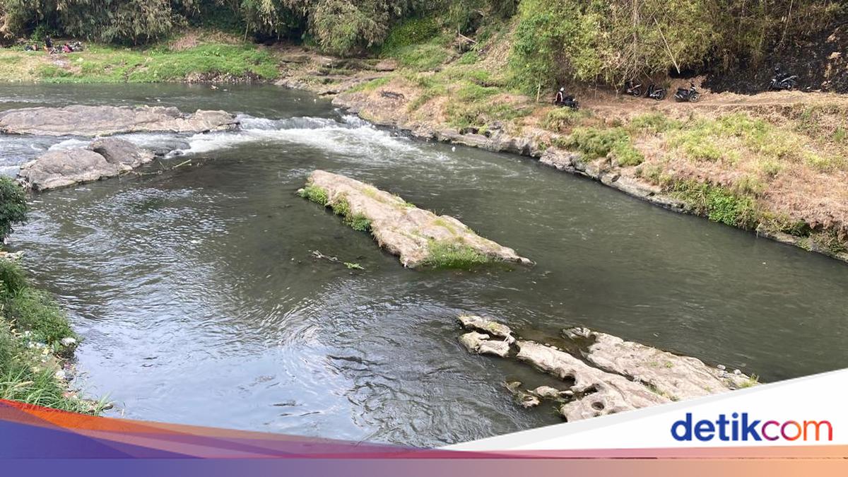 Warga melihat aliran Sungai Brantas di Malang yang berubah warna menjadi ungu